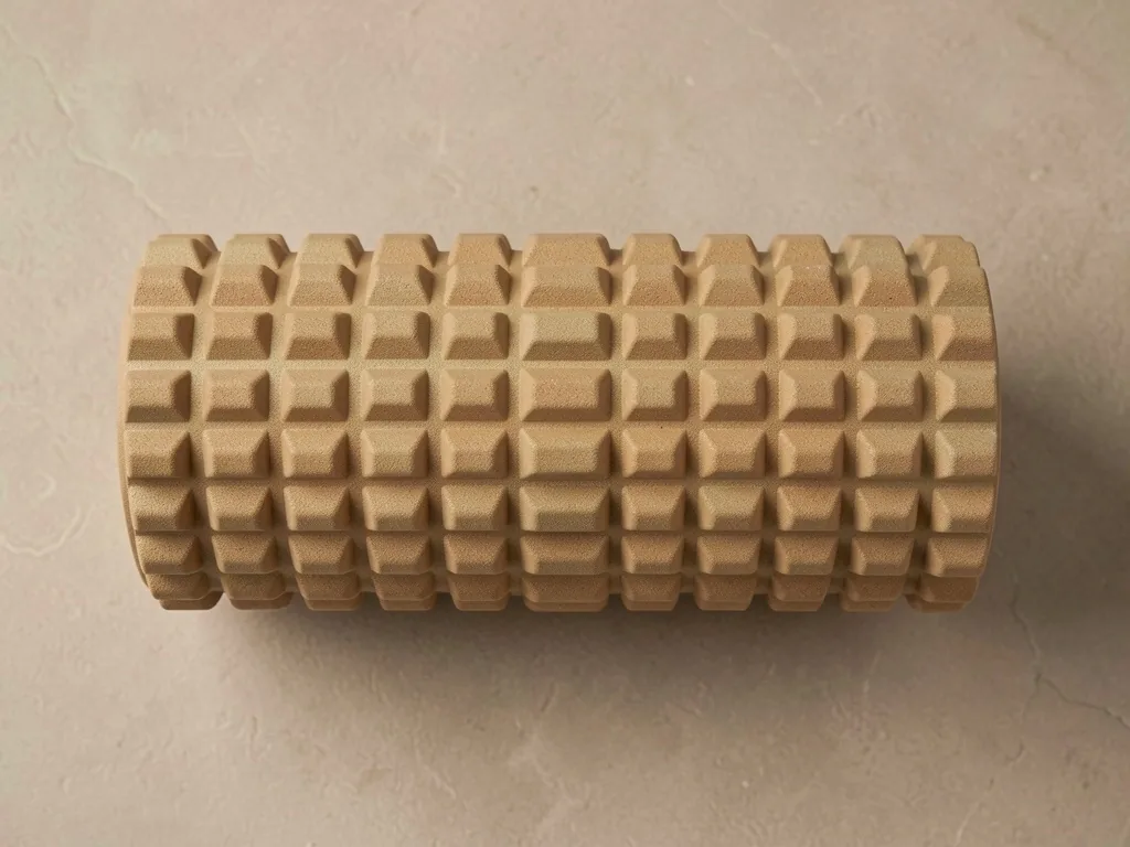 Grid-textured foam roller lying on a stone surface